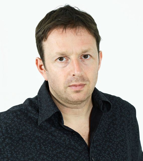 Publicity headshot on white, dark shirt