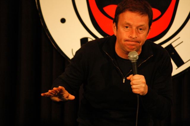 On stage, gesturing to the front row