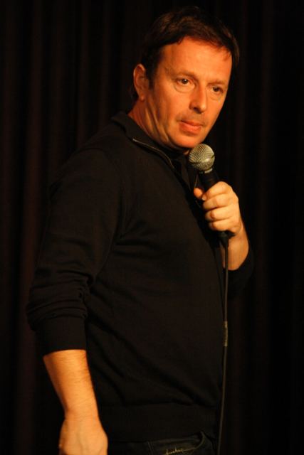Side-on stage shot holding the microphone